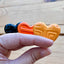 Three Halloween colored hearts in a hand