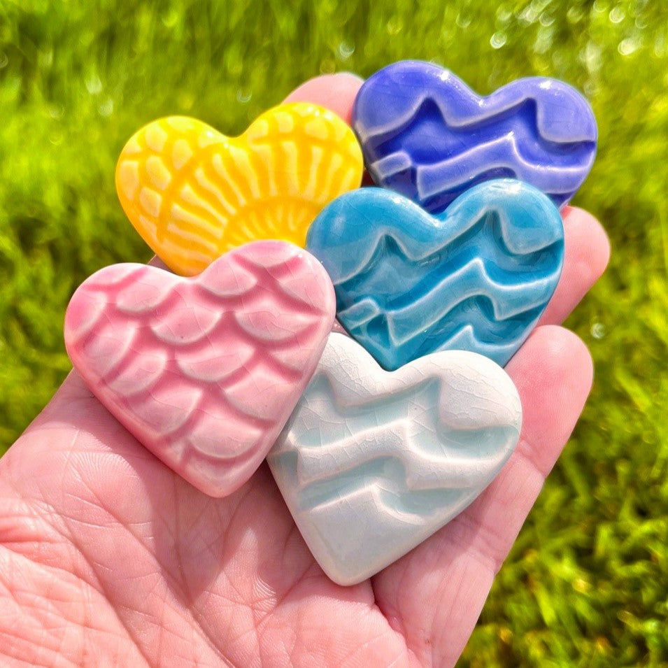 Five colored hearts in a hand
