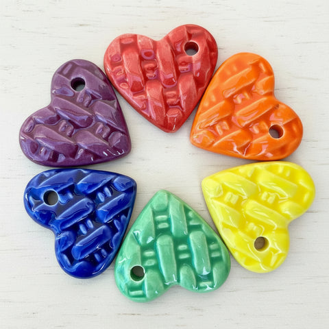 Set of colorful heart-shaped objects on a wooden surface