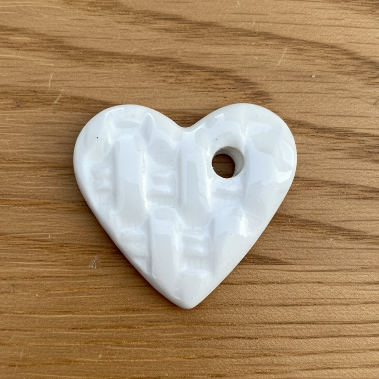 White heart-shaped ceramic on a wood background
