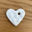 White heart-shaped ceramic on a wood background