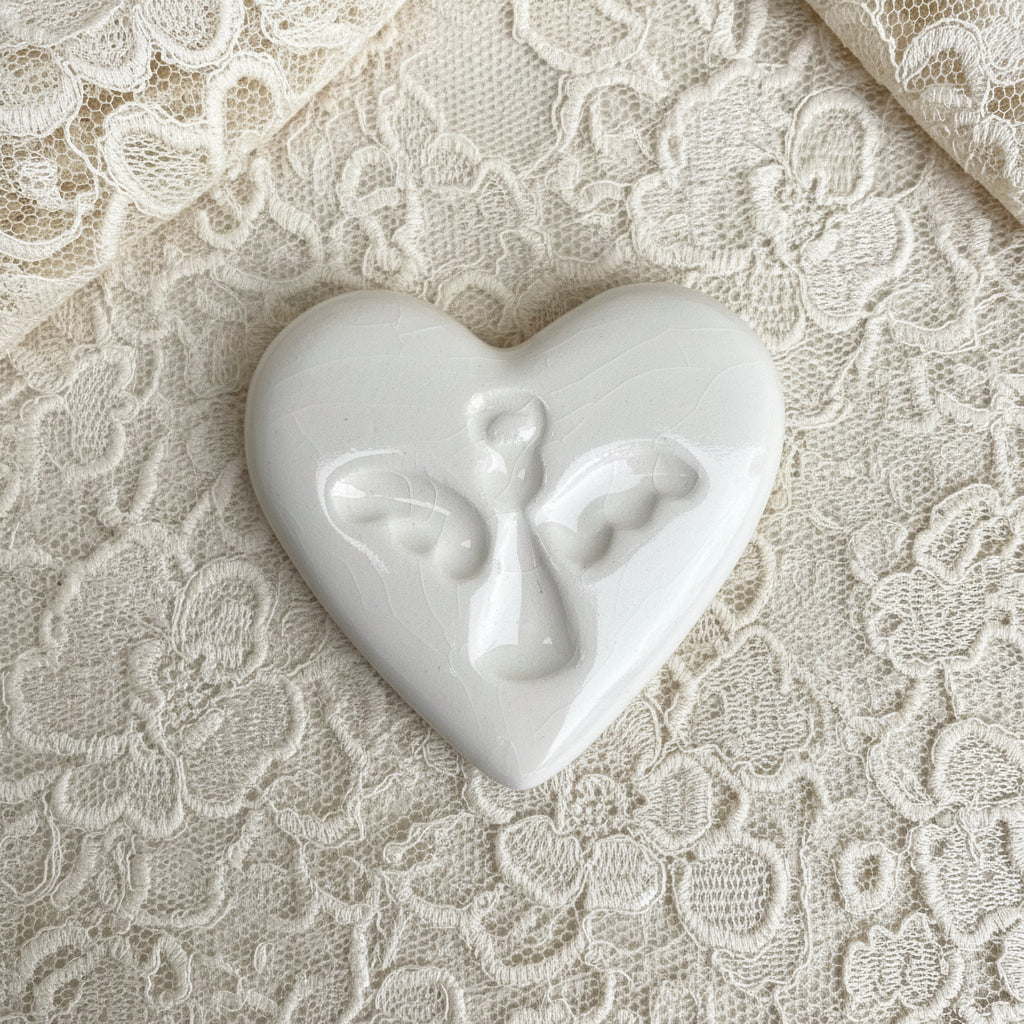 White heart-shaped ceramic with an angel print