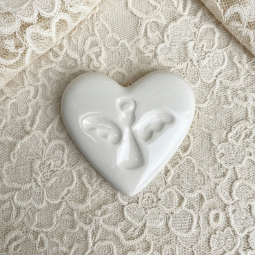 White heart-shaped ceramic with an angel print