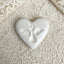 White heart-shaped ceramic with an angel print