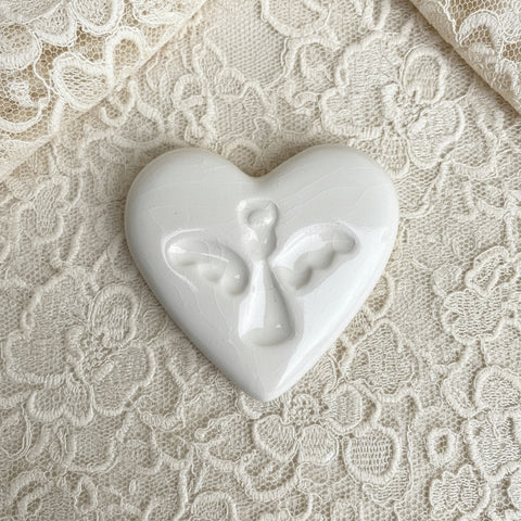 White heart-shaped ceramic with an angel print