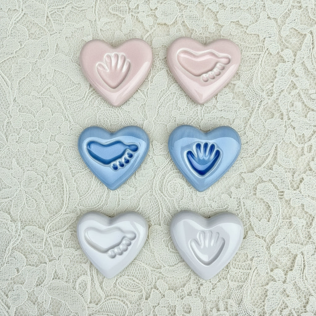 Set of heart-shaped ceramics with hand and footprints on a  lace background