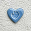 Blue ceramic heart with a handprint on a lace surface