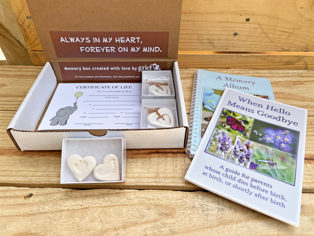 Memory box with items for parents whose child died before birth, including a book and certificate.