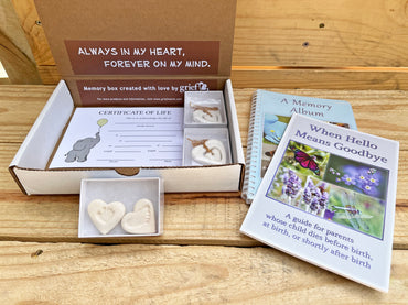 Memory box with items for parents whose child died before birth, including a book and certificate.