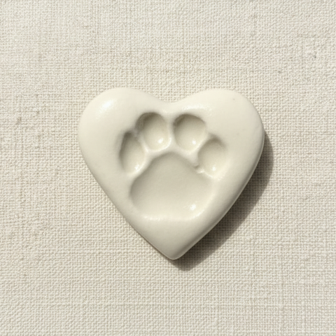 A heart-shaped ceramic with a paw print design.