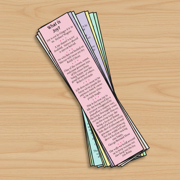 Pink bookmark with text on an open book on a wooden surface