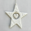 White textured star-shaped ornament with a heart in the center on a beige background