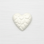White heart-shaped ceramic with embossed design on a white background