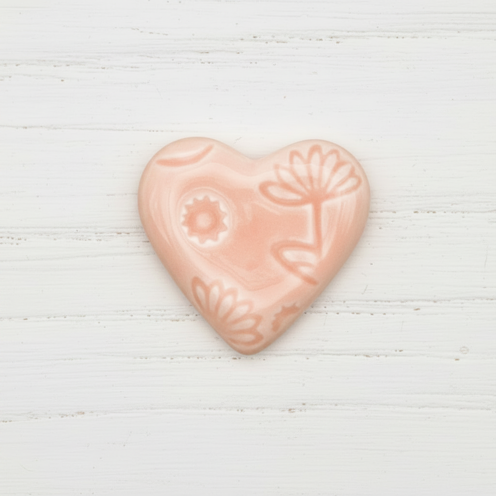 Heart-shaped pink soap with floral design on a white background