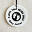 A round, white ceramic footprint ornament with the words 'A LOVE THAT NEVER ENDS' and a space for a name.