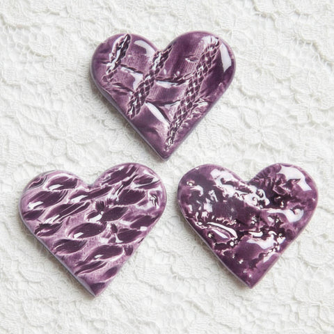 A purple ceramic heart-shaped lapel pin 